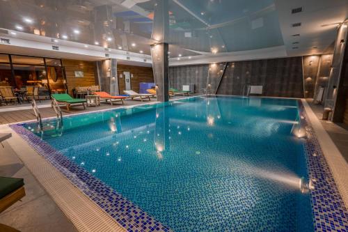 a large swimming pool in a hotel room at Evdo Apartments F2 Lovely Studio in Gudauri