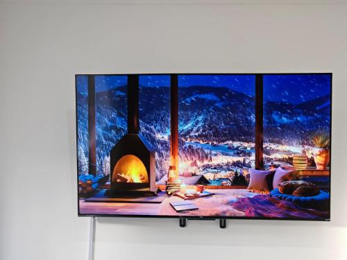 a tv screen with a fireplace on a wall at Sutton Apartment, Greater London in Sutton