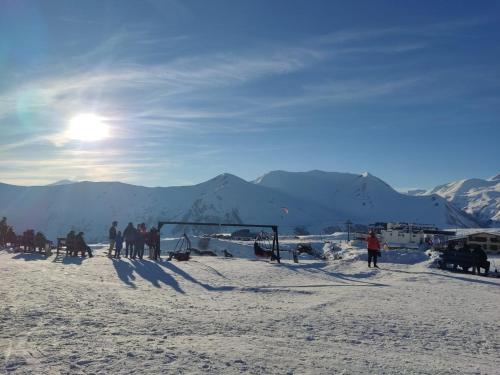 a group of people standing on top of a snow covered slope at Evdo Apartments F2 Lovely Studio in Gudauri