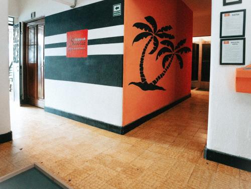 a hallway with a palm tree painted on a wall at Tequila Sunrise Hostel in Guatemala
