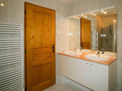 a bathroom with two sinks and a wooden door at La Ferme de Sous-Lachat in Samoëns