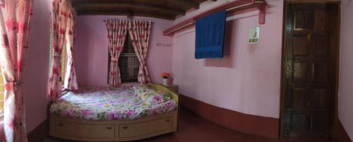 um pequeno quarto com uma cama e uma janela em Roam Alone Roomstay near International airport em Gurpur