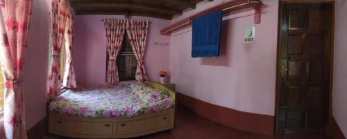 a small bedroom with a bed and a window at Roam Alone Roomstay near International airport in Gurpur