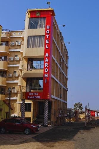 a building with a red sign on the side of it at Hotel Aarohi in Tarapith