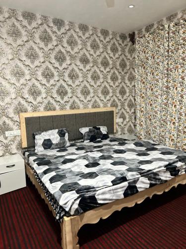 um quarto com uma cama com um edredão preto e branco em Tripzigo hotel em Srinagar