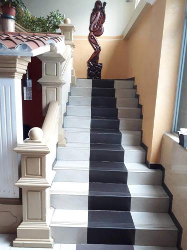 a stairway with black and white tiles and a statue at Hostal zamorano in Quito