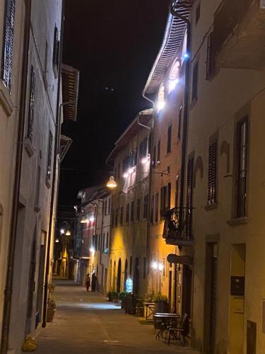 an alley at night with lights on the buildings at LA CASA DEL FALEGNAME in Laterina