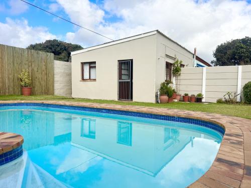 a swimming pool in front of a house at Bob-Bob's Cottage in Cape Town