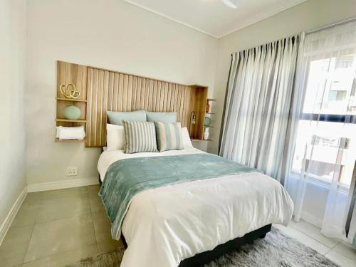 a bedroom with a large bed and a large window at 362@BallitoHills in Ballito