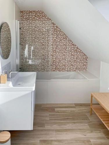 une salle de bain avec un lavabo et une baignoire dans l'établissement Maison neuve à 5 mins des plages, à Erdeven