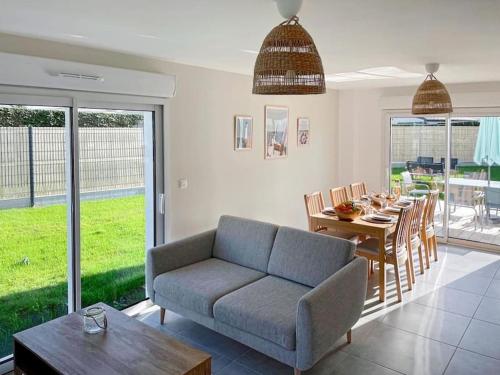 un salon avec un canapé et une table dans l'établissement Maison neuve à 5 mins des plages, à Erdeven