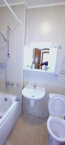 a white bathroom with a toilet and a sink at Апартамент 9 in Pamporovo