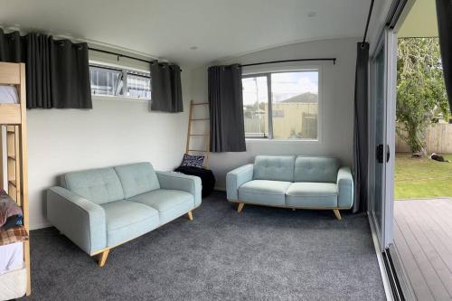 a living room with two chairs and a couch at Black Beauty - Spacious Family Retreat for 12 with Spa in Mangakino