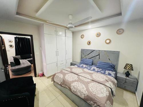 a bedroom with a large bed and a chair at Stylish & Serene 2BHK Apt in Islamabad
