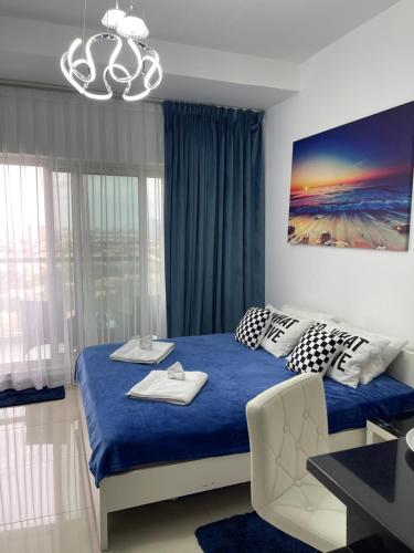 Un dormitorio con una cama azul y una lámpara de araña. en Great view, Dubai SportCity, parking included, nice Apartments en Dubái