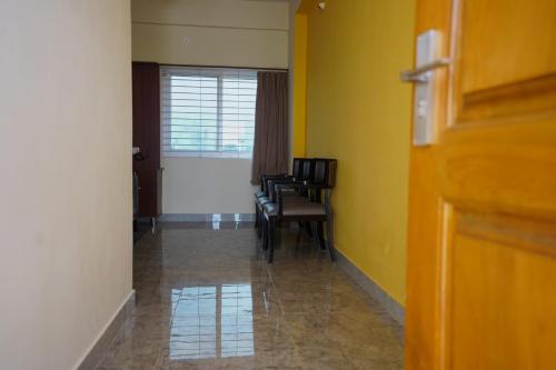 a hallway with chairs and a table in a room at Sri Govindham Home Stay in Tirupati