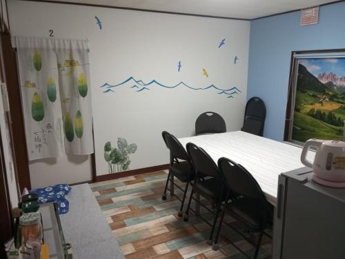 a room with a table and chairs in it at Mike's B&B Tokoname in Tokoname