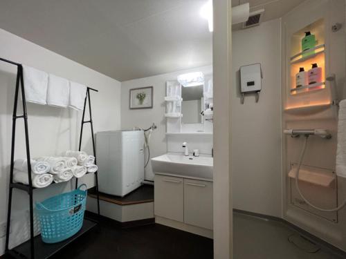 a white bathroom with a sink and a mirror at Le Tour Hotel Akihabara Kandai 楽途ホテル神田秋葉原 in Tokyo