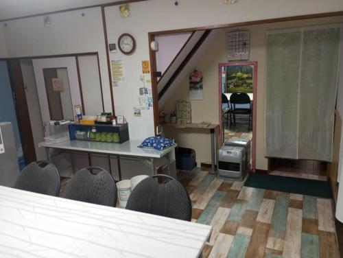 a waiting room with chairs and a counter and a table at Mike's B&B Tokoname in Tokoname