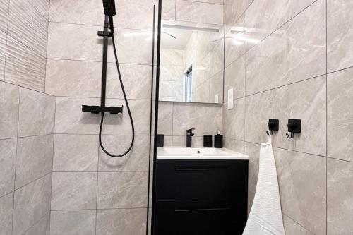 Un baño con ducha, lavabo y espejo. en Le petit cocon de Kintana -Disney-Parking, en Meaux