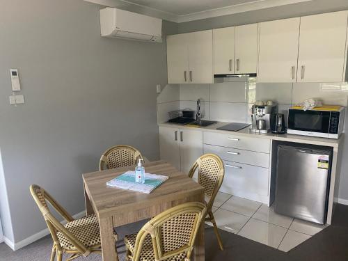 cocina con mesa y sillas y cocina con microondas en Central Oasis, en Coffs Harbour