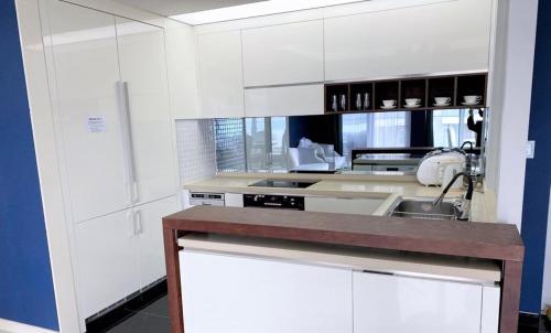 a kitchen with white cabinets and a sink at Ocean Star Condominium in Seogwipo