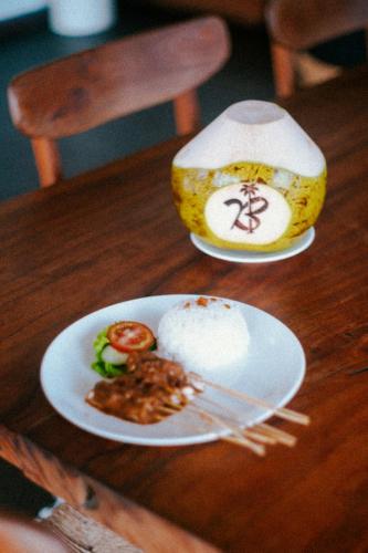 a plate of food on a wooden table at Bombora Medewi in Pulukan