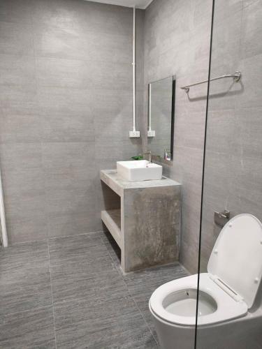 a bathroom with a white toilet and a sink at Nongnuchs Homestay Queen Bed in San Sai