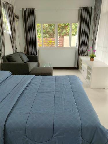 a bedroom with a blue bed and a couch at Nongnuchs Homestay Queen Bed in San Sai