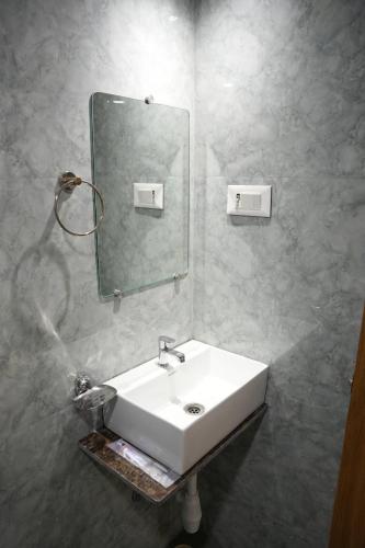 a bathroom with a white sink and a mirror at HOTEL PRESTON in Mumbai