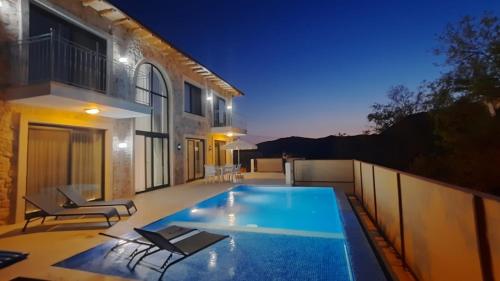 una casa con piscina di notte di Villa Rozerin a Kaş