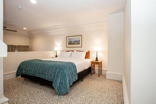 a hotel room with a bed and two lamps at Historic Apartment - Cathedral Square CBD in Christchurch