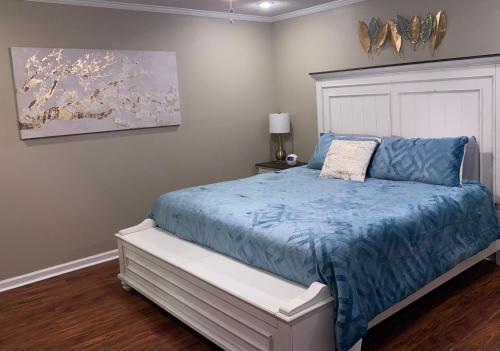 a bedroom with a bed with a blue comforter at Welcome to Cozy and Quiet Residence in Valdosta