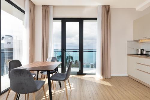 a kitchen and dining room with a table and chairs at Next Green Aparthotel OFFICIAL in Batumi