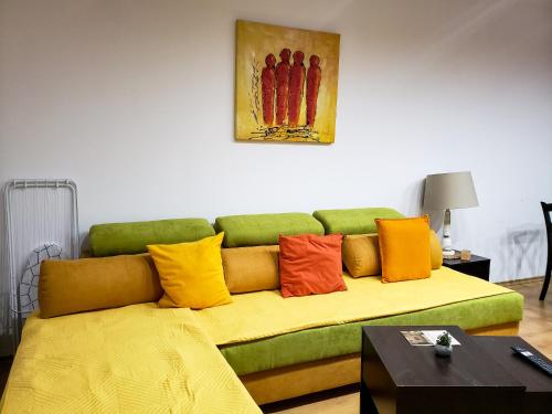 a green couch with colorful pillows in a living room at Semiramida gardens Apartment 23 in Borovets
