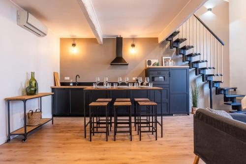 une cuisine avec un bar avec des tabourets et un escalier dans l'établissement RARE ! Stylish duplex in the heart of Cannes, à Cannes