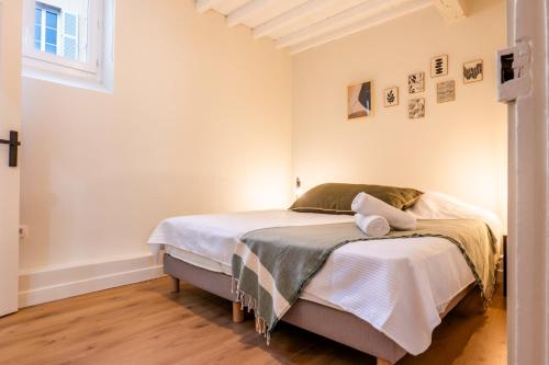 une chambre avec un lit avec des draps blancs et une fenêtre dans l'établissement RARE ! Stylish duplex in the heart of Cannes, à Cannes