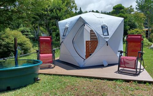 a tent on a deck with chairs and a pool at Mt Fuji View Villa Fujino Kirameki Fujigotemba in Gotemba