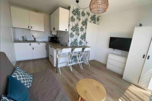 une cuisine avec une table et des chaises dans une pièce dans l'établissement Studio for 4 people near the beach with air conditioning, à Palavas-les-Flots
