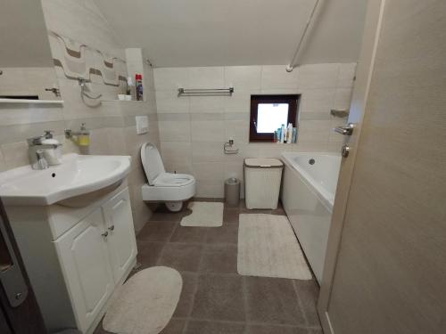 een witte badkamer met een wastafel en een toilet bij Stan Ledine in Ledine