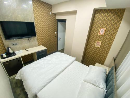a hotel room with a bed and a flat screen tv at FLORYA EXPRESS APART in Istanbul