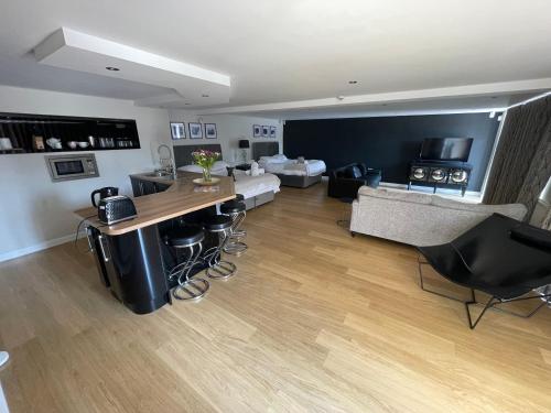 a living room with a kitchen and a living room with a table at Fernside Barn - Studio Apartment in Pickmere