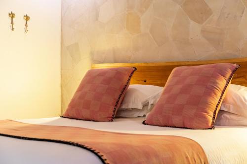 a bedroom with a bed with two pillows on it at Bombora Medewi in Pulukan