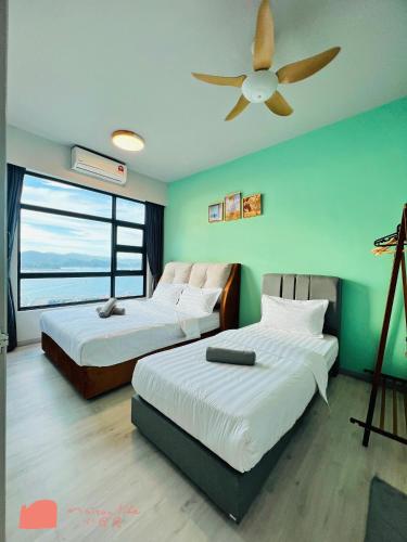a bedroom with two beds and a ceiling fan at Maison life 小居屋 Jesselton Quay CityPads in Kota Kinabalu