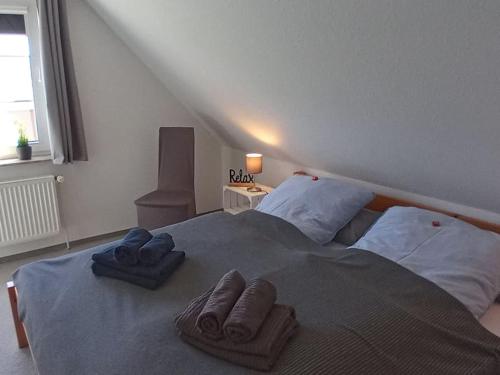 a bedroom with a bed with two towels on it at Ferienhaus Finkenburg im Herzen Ostfrieslands in Wirdum