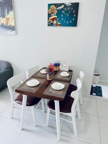 a dining room table with chairs and a clock on the wall at Masteri An Phu - Condo 1-2BR Apartment with Pool GYM D2 in Ho Chi Minh City