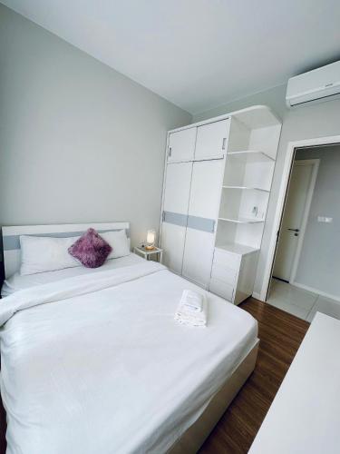 a bedroom with a large white bed with a purple pillow at Masteri An Phu - Condo 1-2BR Apartment with Pool GYM D2 in Ho Chi Minh City