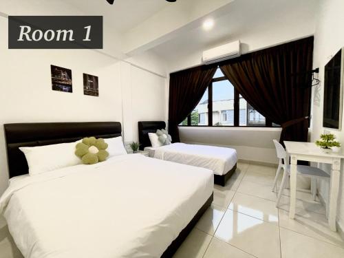 a hotel room with two beds and a desk at The Urban Lodge 2 in Kuala Terengganu