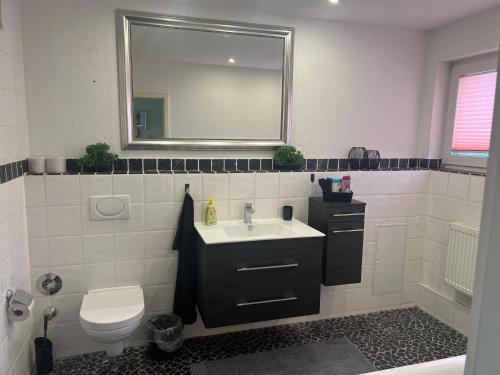 a bathroom with a sink and a toilet and a mirror at Sehr große Wohnung nähe Düsseldorf, Flughafen und Messe in Duisburg