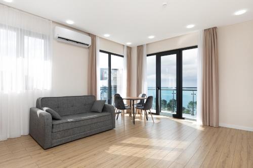 a living room with a couch and a table with chairs at Next Green Aparthotel OFFICIAL in Batumi